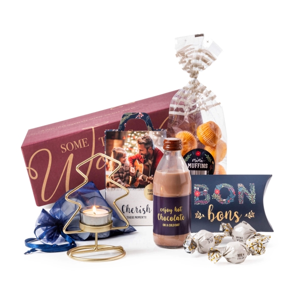 Kerstpakket voor in de brievenbus met kaarsjes en chocolade.